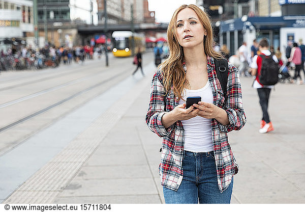 Woman with smartphone in the city  Berlin  Germany