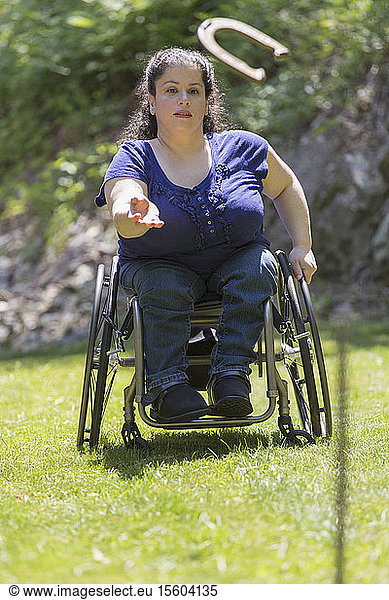 Woman with Spina Bifida in a wheelchair playing horseshoes