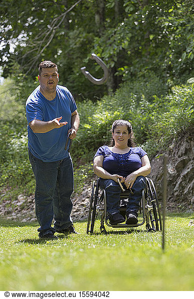 Woman with Spina Bifida in a wheelchair playing horseshoes with her husband
