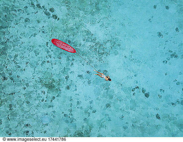 Woman with surfboard swimming in sea at Huraa island  Maldives