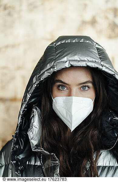 Woman with warm clothing wearing protective face mask