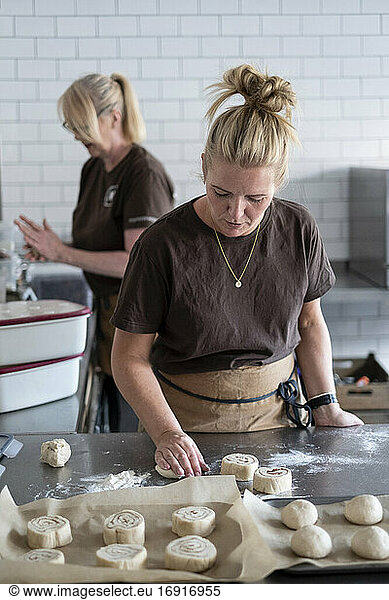 Woman working in a kitchen  preparing danish pastries dough.