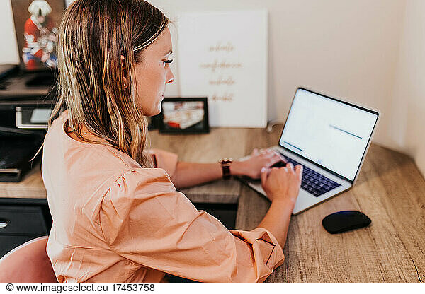 Woman works from home office on laptop computer