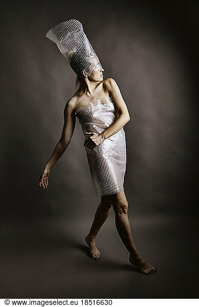 Woman wrapped in plastic posing in studio