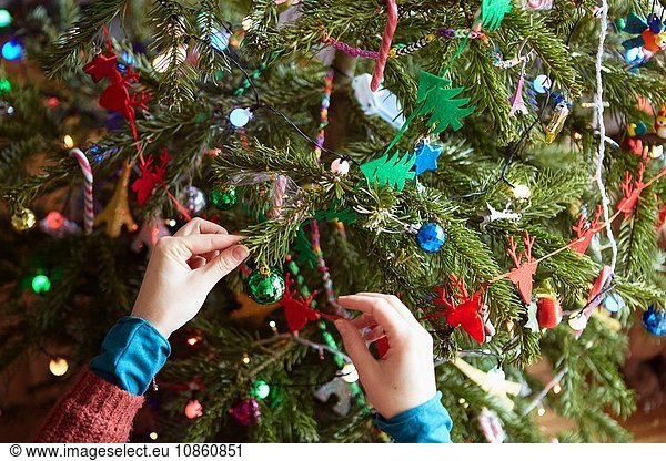 Womans hands preparing xmas decorations on xmas tree