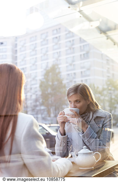 Women drinking tea at sidewalk cafe