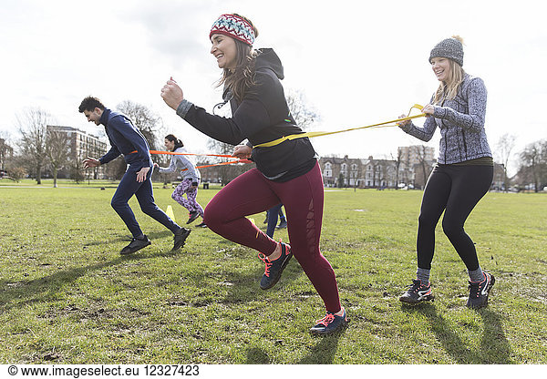 Women exercising, doing team building exercise in park