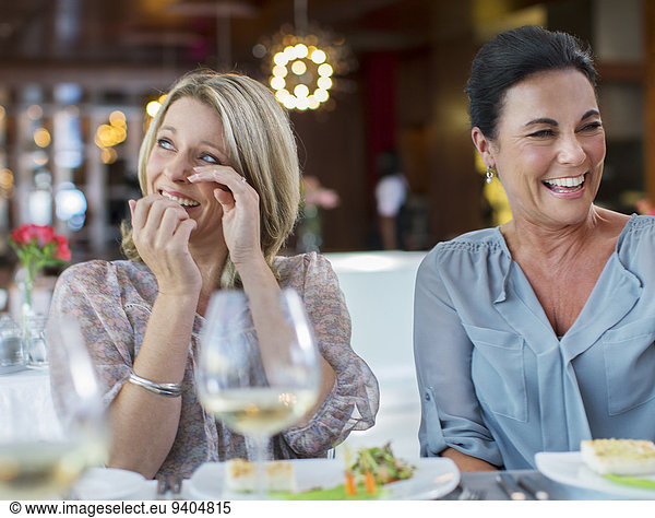 Women laughing at table in restaurant
