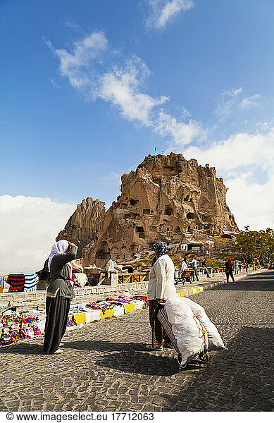 Women On The Road With Uchisar Castle In The Background; Uchisar  Cappadocia  Turkey