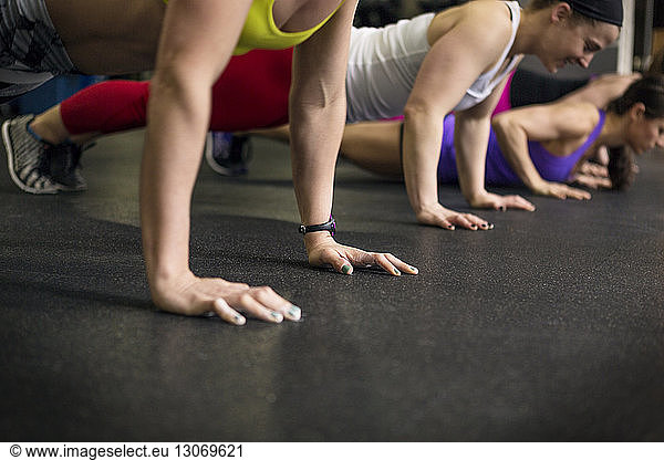 Women practicing push-ups in gym