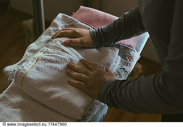 Women's hands on a stack of ironed linen