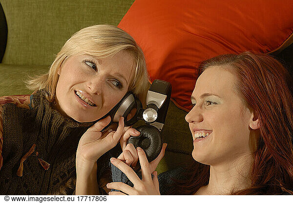 Women Sharing And Listening To Headphones