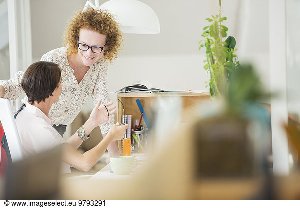 Women talking and smiling in office