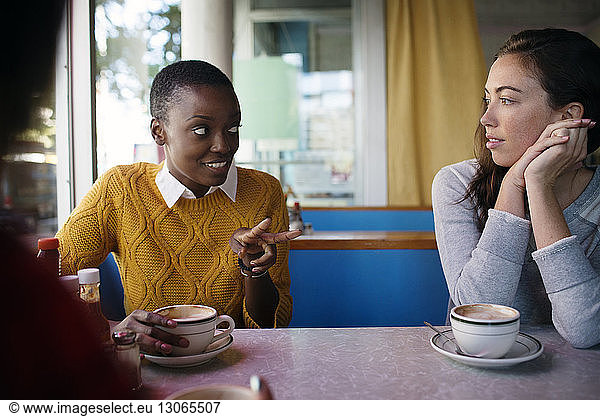 Women talking while sitting in cafe