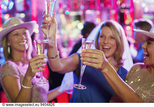 Women toasting with champagne flutes at bachelorette party