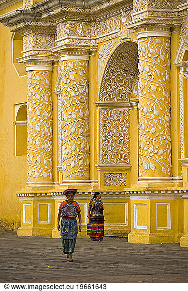 Women walking in front of the church La Merced  Antigua  Guatemala