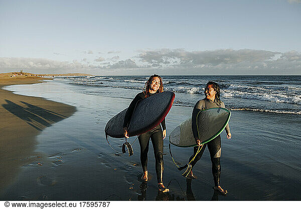 Women walking with surfboards near sea at beach  Gran Canaria  Canary Islands
