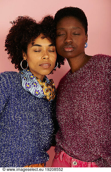 Women with eyes closed against peach background