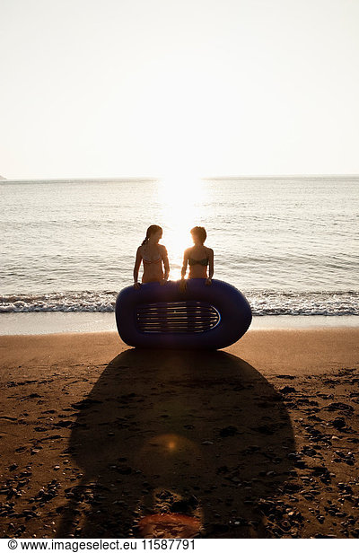 Women with inflatable boat on beach