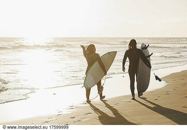 Women with surfboards walking at beach on sunset  Gran Canaria  Canary Islands