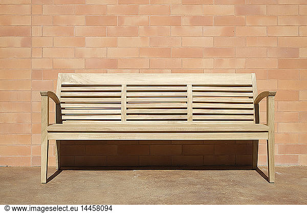 Wooden Bench Set Against Brick Wall