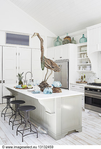 Wooden bird sculpture on dining table in kitchen at cottage