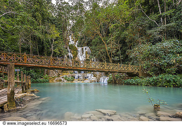 Wooden bridge over river against Kuang Si waterfalls  Luang Prabang  Laos
