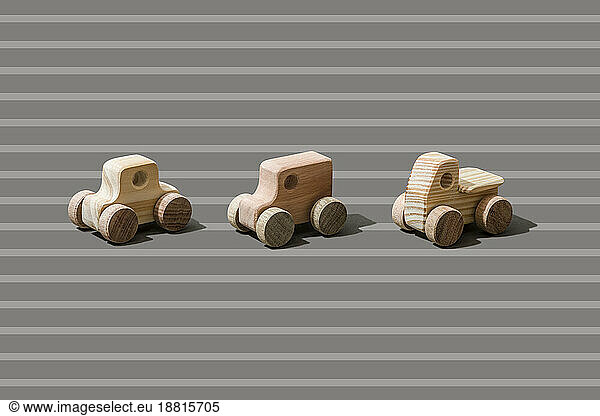 Wooden cars on stripped background