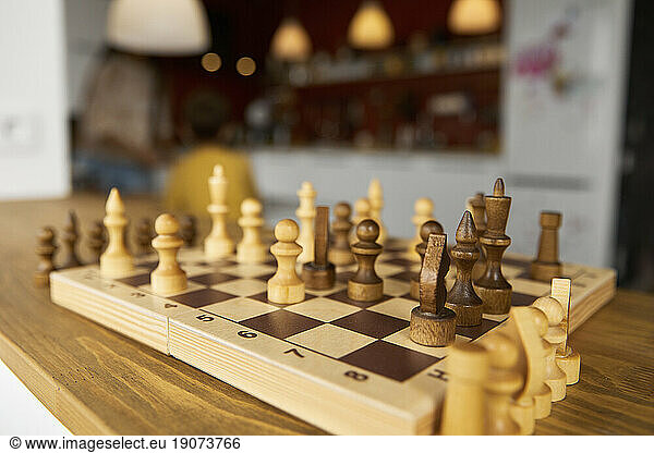 Wooden chess board with pieces on window sill