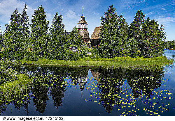 Wooden church reflecting in shiny lake