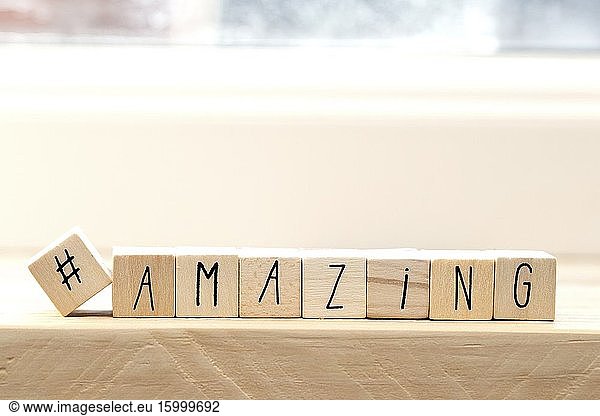 Wooden cubes with a hashtag and the word amazing  social media concept background.