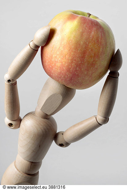 Wooden doll with an apple  symbolic image for healthy food