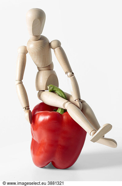 Wooden doll with red bell pepper  symbolic image for healthy food