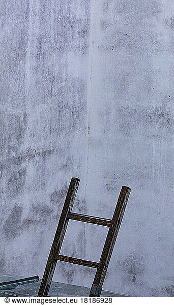 Wooden ladder leaning in front of wall