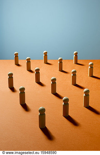 Wooden pawn chess pieces on orange surface