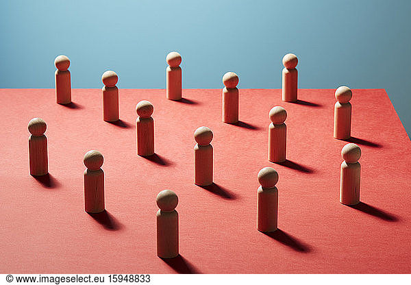 Wooden pawn chess pieces on red surface