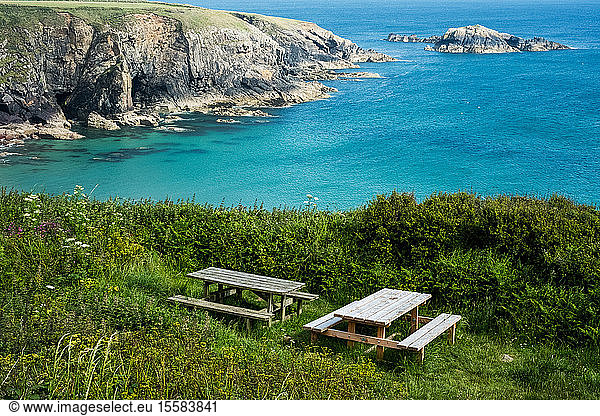 Wooden picnic tables on a cliff on the Pembrokeshire Coast  Wales  UK.