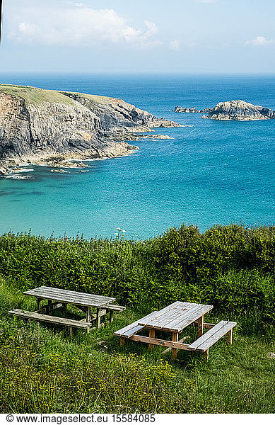 Wooden picnic tables on a cliff on the Pembrokeshire Coast  Wales  UK.