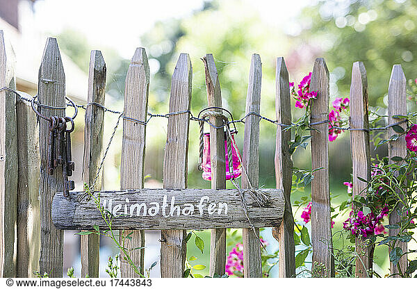 Wooden sign and old key ring hanging on rustic fence