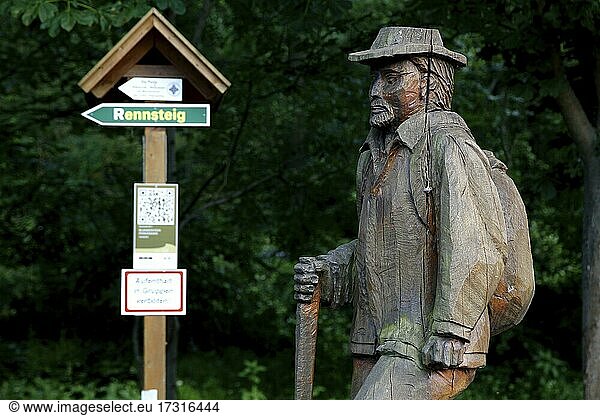 Wooden statue hiker with hat  sign Rennsteig  signpost to the Rennsteig  Rennsteig  high hiking trail  Thuringian Forest  Green Belt  border trail  former German-German border  Blankenstein  Saale-Orla district  Thuringia  Germany  Europe