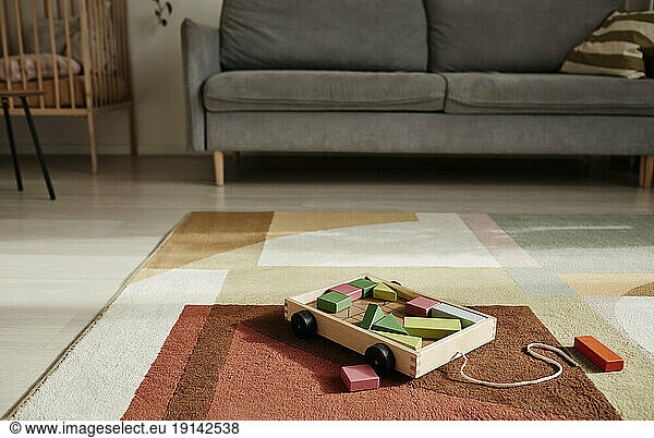 Wooden toy cart on carpet in living room at home