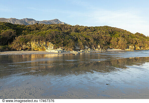 Woodland and mountains scenery  a small sheltered sandy beach on the Atlantic shore.