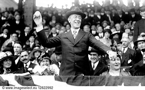 WOODROW WILSON (1856-1924). 28th President of the United States. President Wilson throwing out the ceremonial first ball on opening day of the 1916 major league baseball season  Washington  D.C. First Lady Edith Wilson smiles at left.