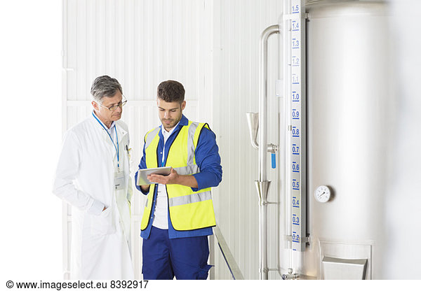 Worker and scientist talking in food processing plant