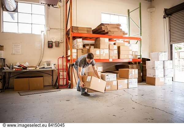 Worker lifting cardboard box
