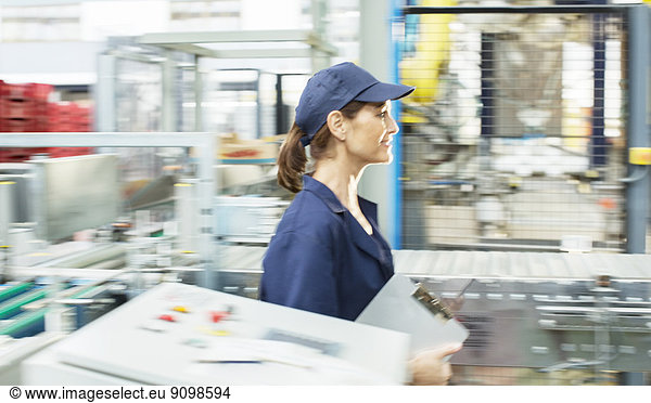 Worker with clipboard walking in food processing plant