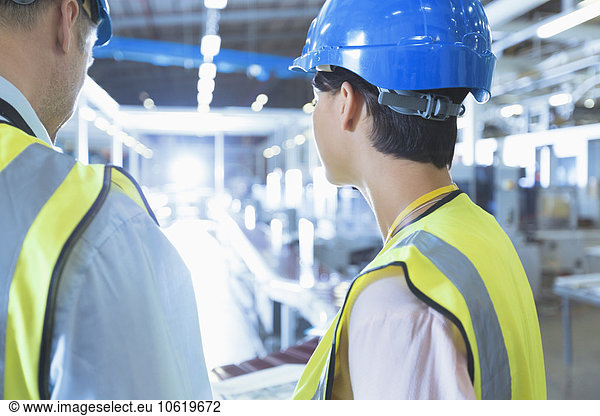 Workers in reflective clothing and hard-hat in factory