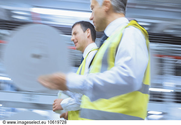 Workers in reflective clothing walking in factory