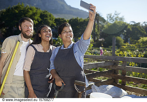 Workers posing for selfie at sunny plant nursery