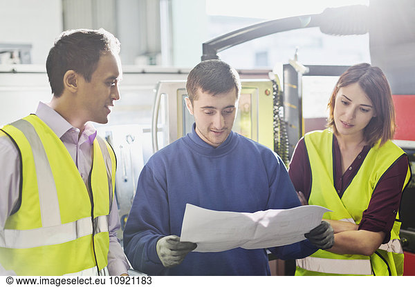 Workers reviewing paperwork in steel factory